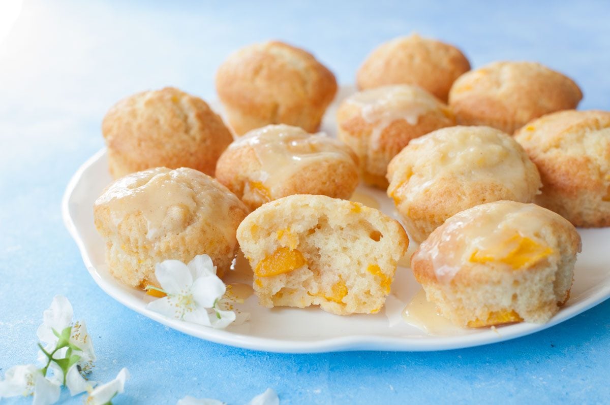 mango muffins with passion fruit glaze on a white plate (close up shot)
