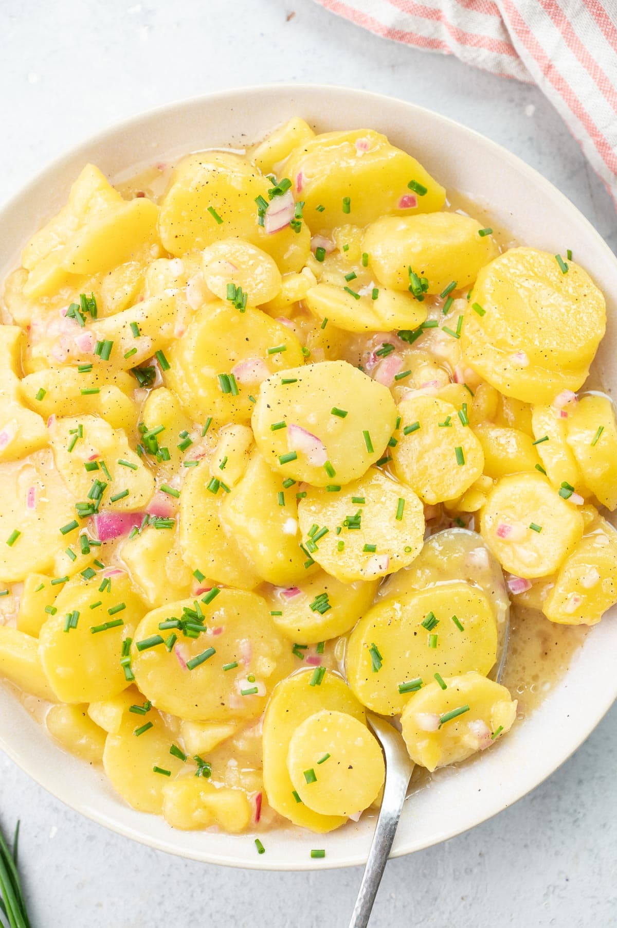 Austrian potato salad in a beige bowl.