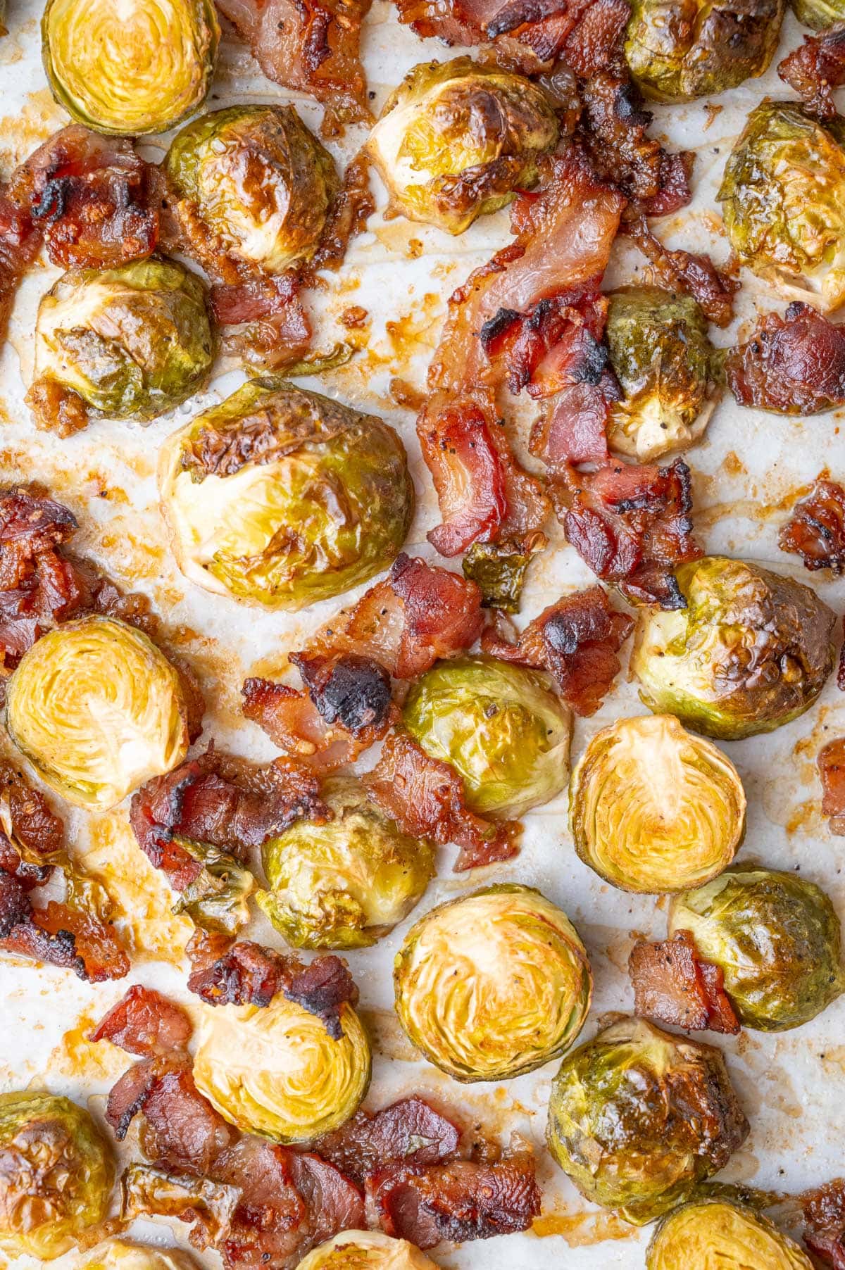 Roasted Brussels sprouts with bacon on a baking sheet.